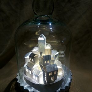 Kleine Stadt mit Trafo-Häuschen unter einer Glasglocke