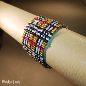 Aus Glasperlen gewebtes Armband *Tartan in Gold, Schwarz, Weiß und Rot*